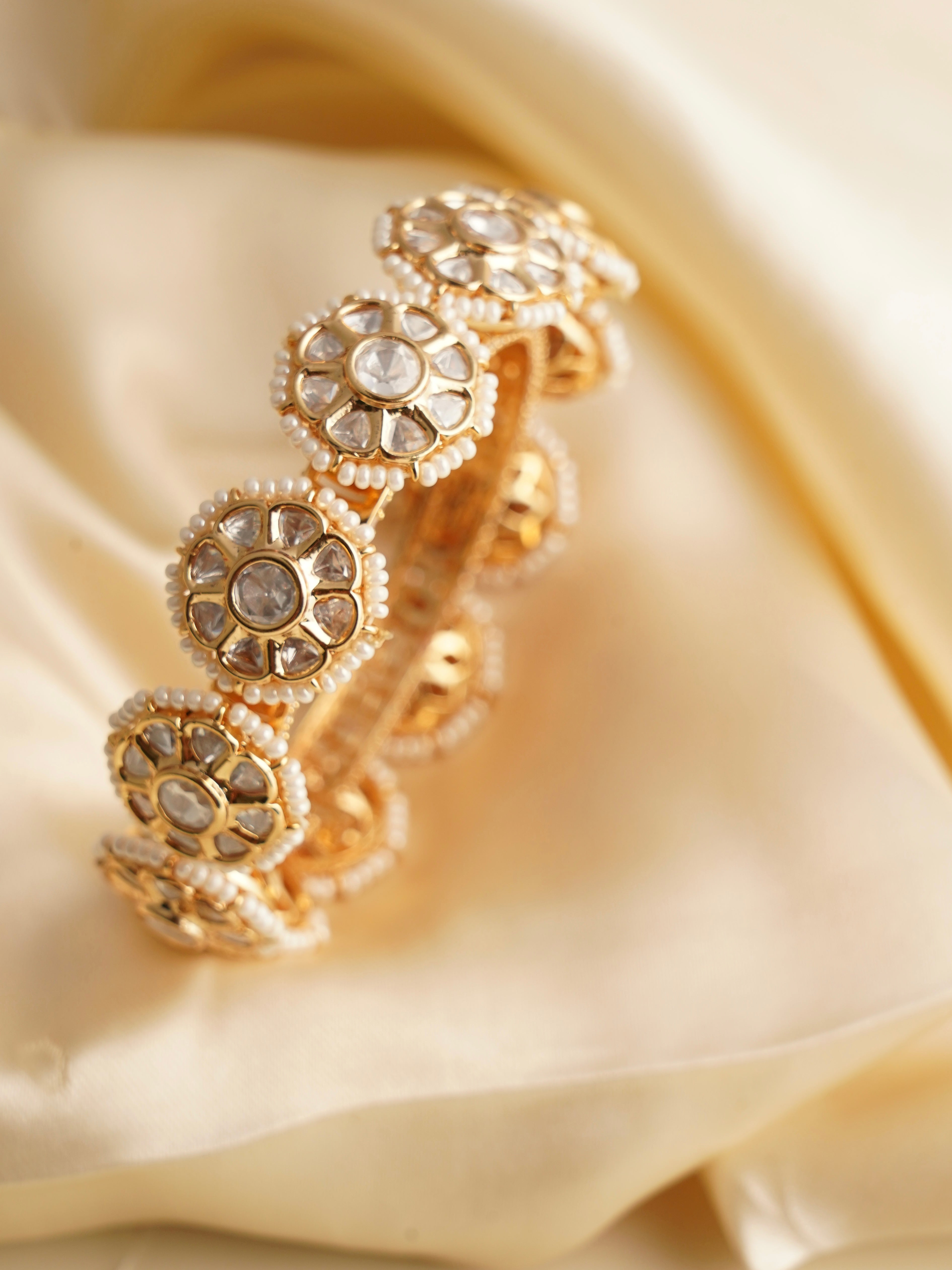 Floral gold bangles set with kundan stones and pearl accents, handcrafted openable design